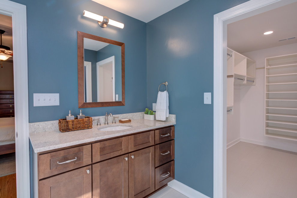 Идея дизайна: главная ванная комната среднего размера в современном стиле с фасадами в стиле шейкер, темными деревянными фасадами, угловым душем, унитазом-моноблоком, белой плиткой, керамической плиткой, синими стенами, полом из керамической плитки, врезной раковиной, столешницей из искусственного кварца, серым полом, душем с распашными дверями, бежевой столешницей, нишей, тумбой под две раковины и встроенной тумбой