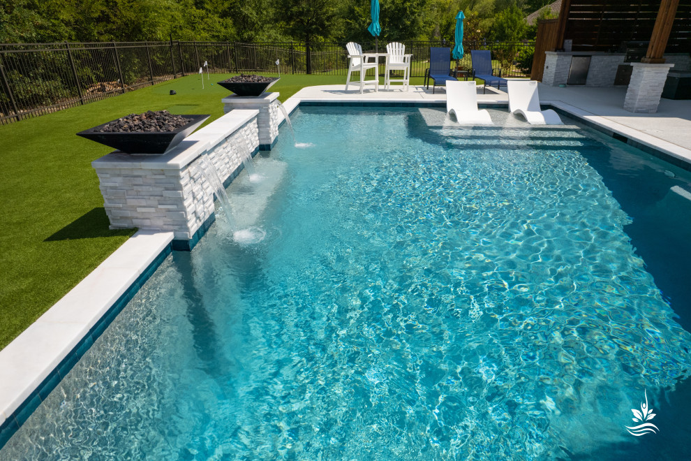 This is an example of a large modern backyard rectangular natural pool in Dallas with with a pool and decking.
