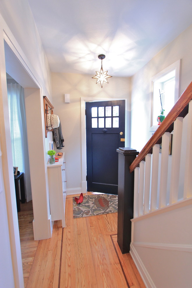 This is an example of a small eclectic front door in Toronto with a blue front door, grey walls, light hardwood floors and a single front door.