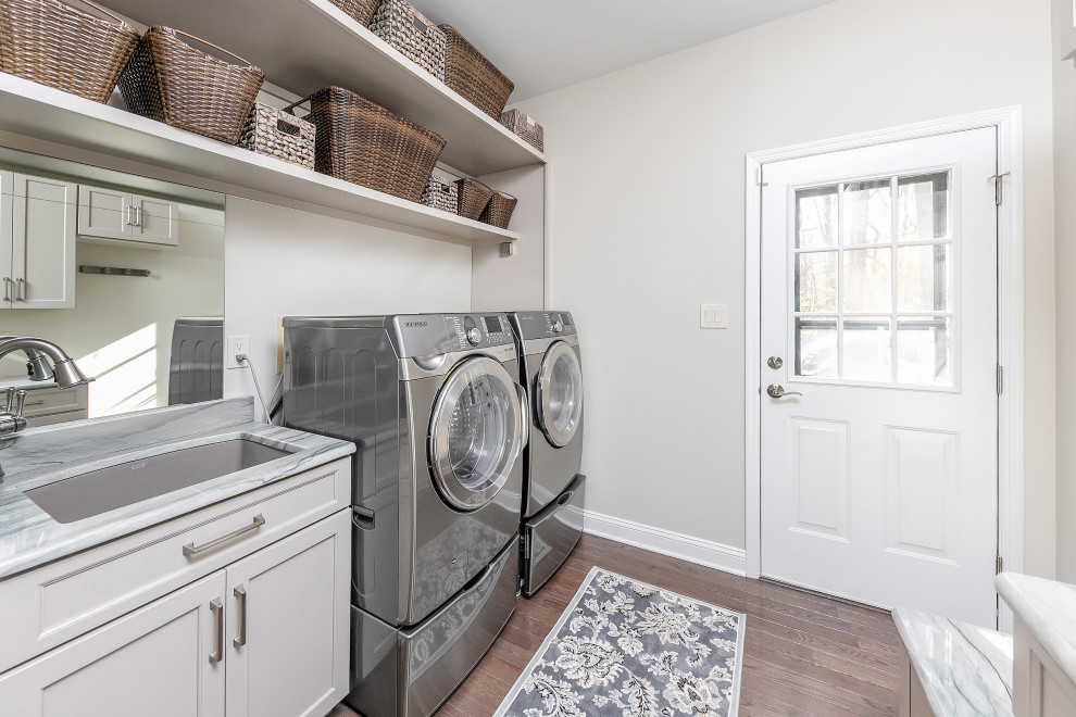 This is an example of a mid-sized transitional laundry room in Philadelphia with an undermount sink, raised-panel cabinets, dark wood cabinets, quartzite benchtops, white splashback, ceramic splashback and white benchtop.