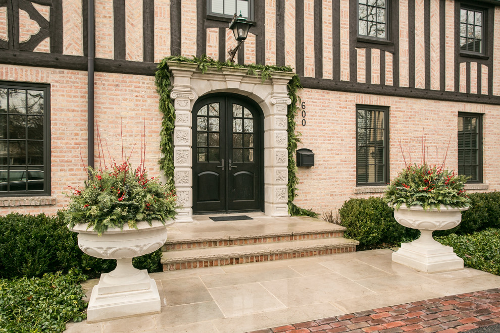 Inspiration for a large timeless front yard stone full sun double front door remodel for winter in Chicago with a black front door