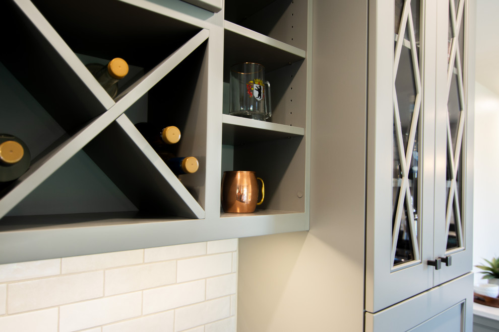 Kitchen - mid-sized transitional l-shaped medium tone wood floor and brown floor kitchen idea with an undermount sink, recessed-panel cabinets, gray cabinets, quartz countertops, white backsplash, ceramic backsplash, stainless steel appliances, a peninsula and white countertops