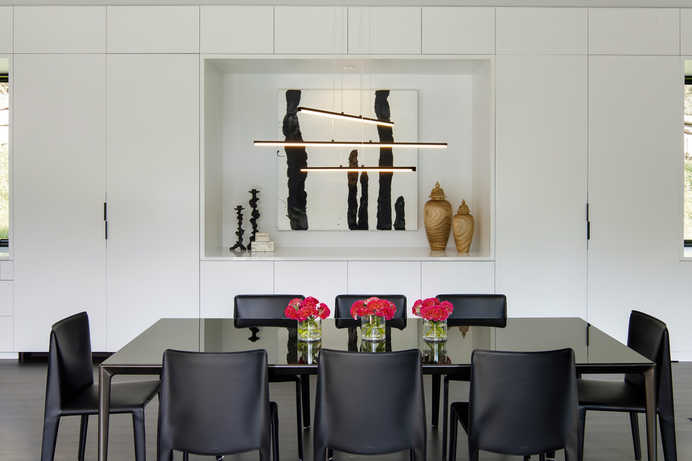 Contemporary open plan dining in Minneapolis with dark hardwood floors, white walls and black floor.