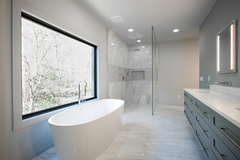This is an example of a mid-sized modern master bathroom in Other with shaker cabinets, grey cabinets, a freestanding tub, an open shower, a two-piece toilet, gray tile, marble, grey walls, marble floors, an undermount sink, marble benchtops, grey floor, an open shower and white benchtops.