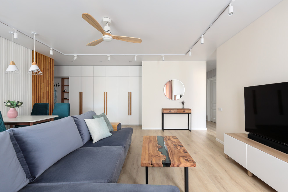 Esempio di un soggiorno nordico di medie dimensioni con pareti beige, TV autoportante e pavimento marrone