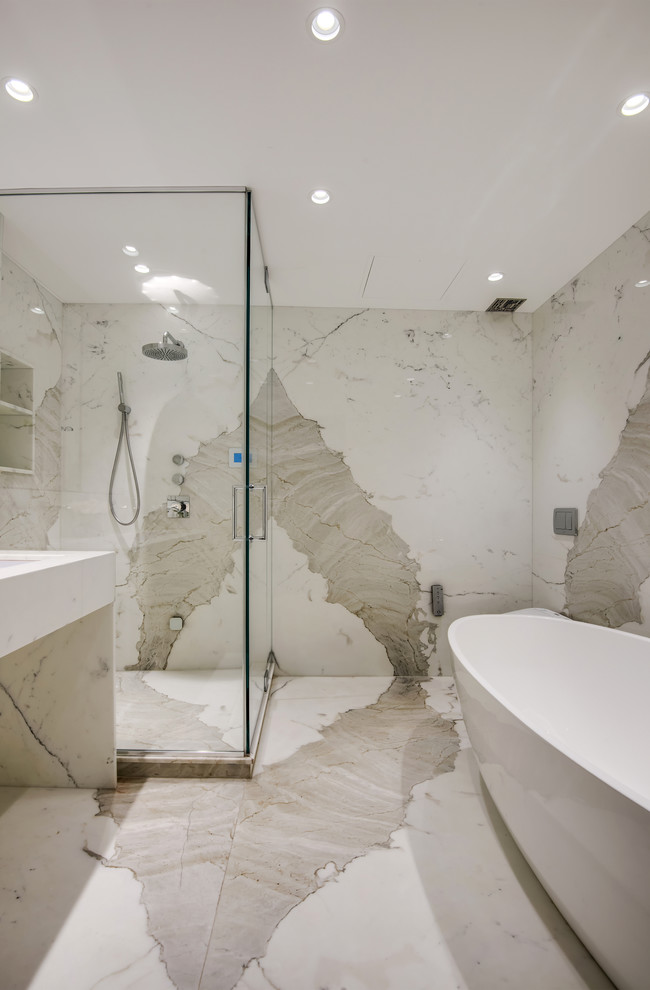 Inspiration for a mid-sized contemporary master bathroom in New York with a freestanding tub, a corner shower, marble, white walls, marble floors, a trough sink, marble benchtops, white floor, a hinged shower door and white benchtops.