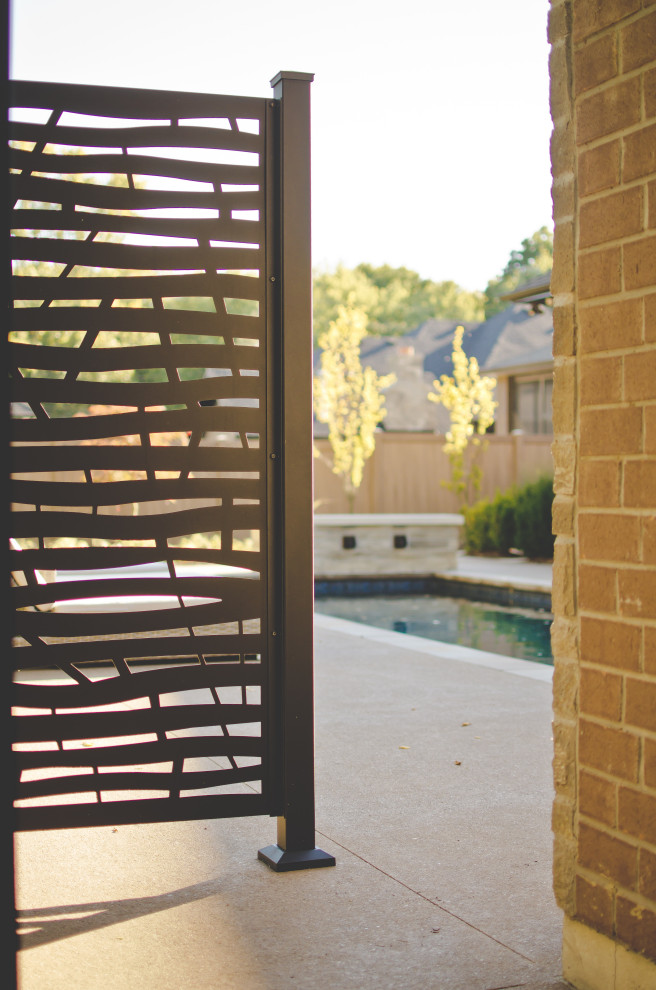 Immagine di un piccolo privacy in giardino tradizionale dietro casa con pavimentazioni in cemento e recinzione in metallo