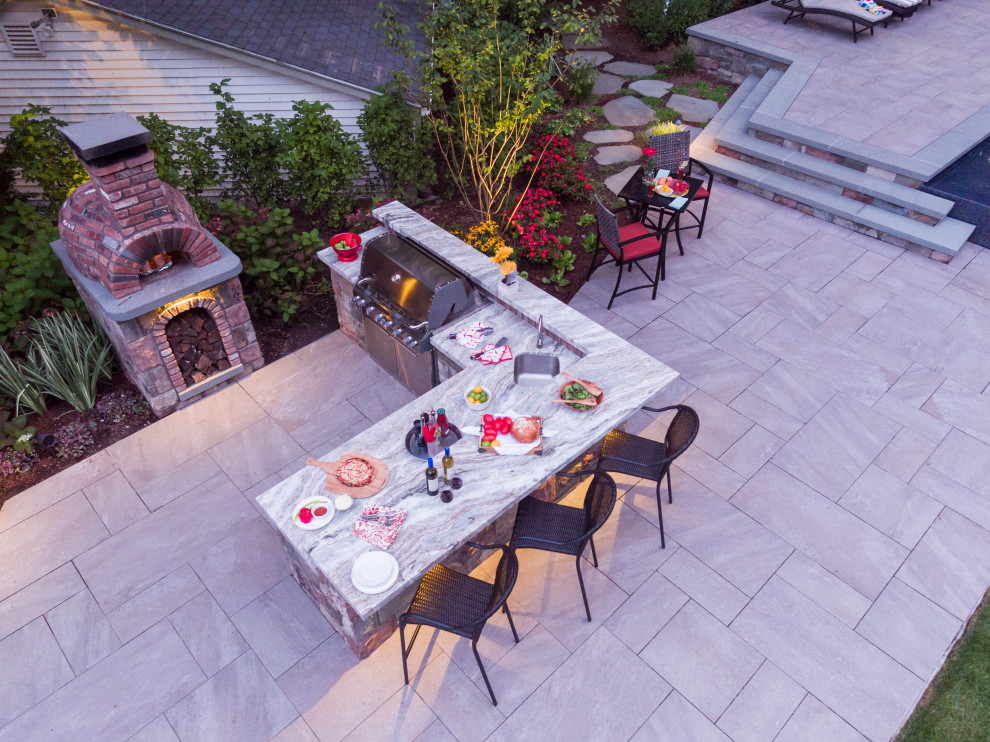 Photo of a large contemporary backyard patio in New York with tile.