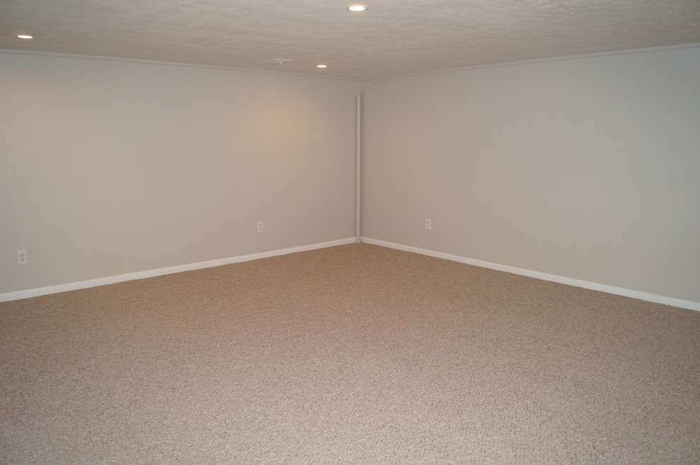 This is an example of a mid-sized modern fully buried basement in Cleveland with grey walls and carpet.