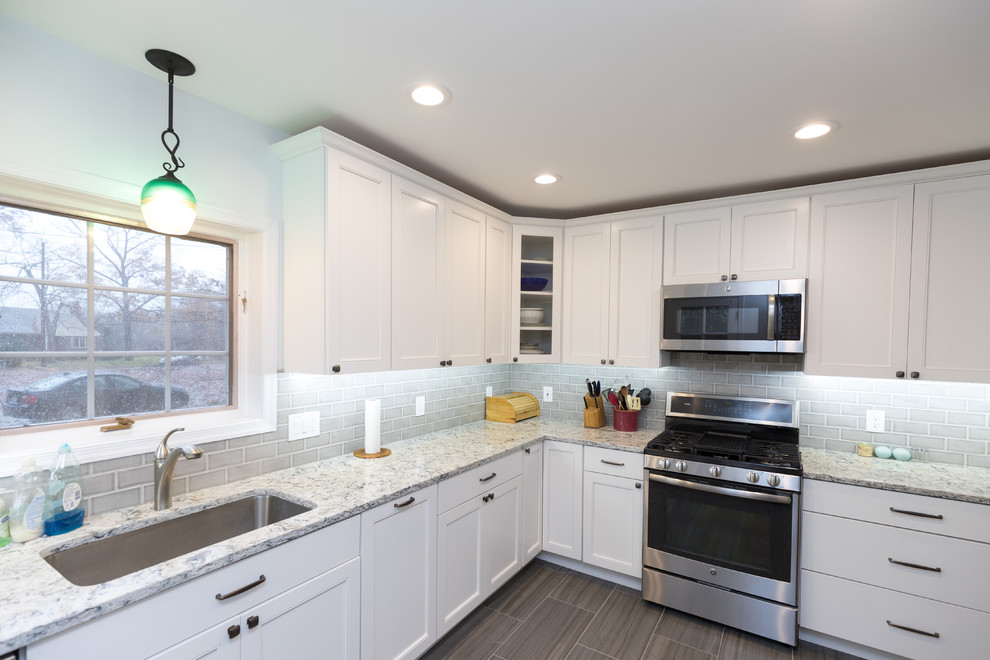 Enclosed kitchen - mid-sized transitional l-shaped porcelain tile and brown floor enclosed kitchen idea in San Diego with an undermount sink, beaded inset cabinets, white cabinets, granite countertops, gray backsplash, ceramic backsplash, stainless steel appliances, no island and gray countertops