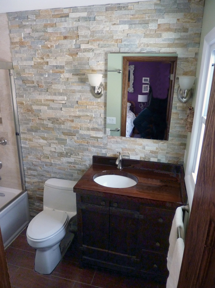 Example of a small mountain style master multicolored tile and stone tile porcelain tile bathroom design in New York with an undermount sink, furniture-like cabinets, dark wood cabinets, wood countertops, a one-piece toilet and green walls