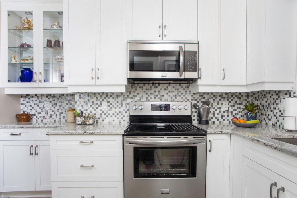 Inspiration for a mid-sized transitional u-shaped vinyl floor enclosed kitchen remodel with an undermount sink, shaker cabinets, white cabinets, granite countertops, gray backsplash, mosaic tile backsplash, stainless steel appliances and no island