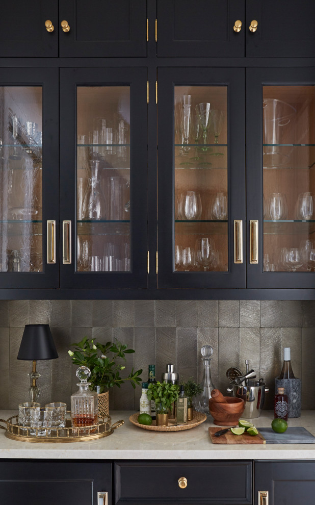 Foto di una cucina abitabile boho chic con ante di vetro, ante nere, paraspruzzi a effetto metallico, parquet chiaro, pavimento marrone e top bianco