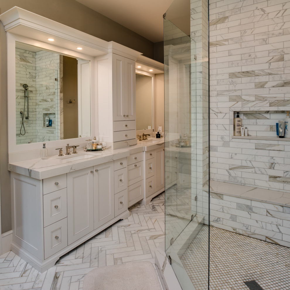 Design ideas for a mid-sized transitional bathroom in Detroit with furniture-like cabinets, grey cabinets, a corner shower, white tile, marble, beige walls, marble floors, an undermount sink, engineered quartz benchtops, white floor, a hinged shower door and white benchtops.
