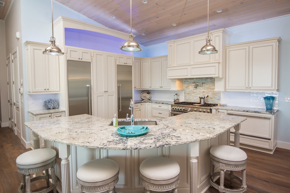 Design ideas for a large beach style l-shaped kitchen in Jacksonville with an undermount sink, stainless steel appliances, brown floor, recessed-panel cabinets, beige cabinets, granite benchtops, white splashback, glass sheet splashback, dark hardwood floors and with island.