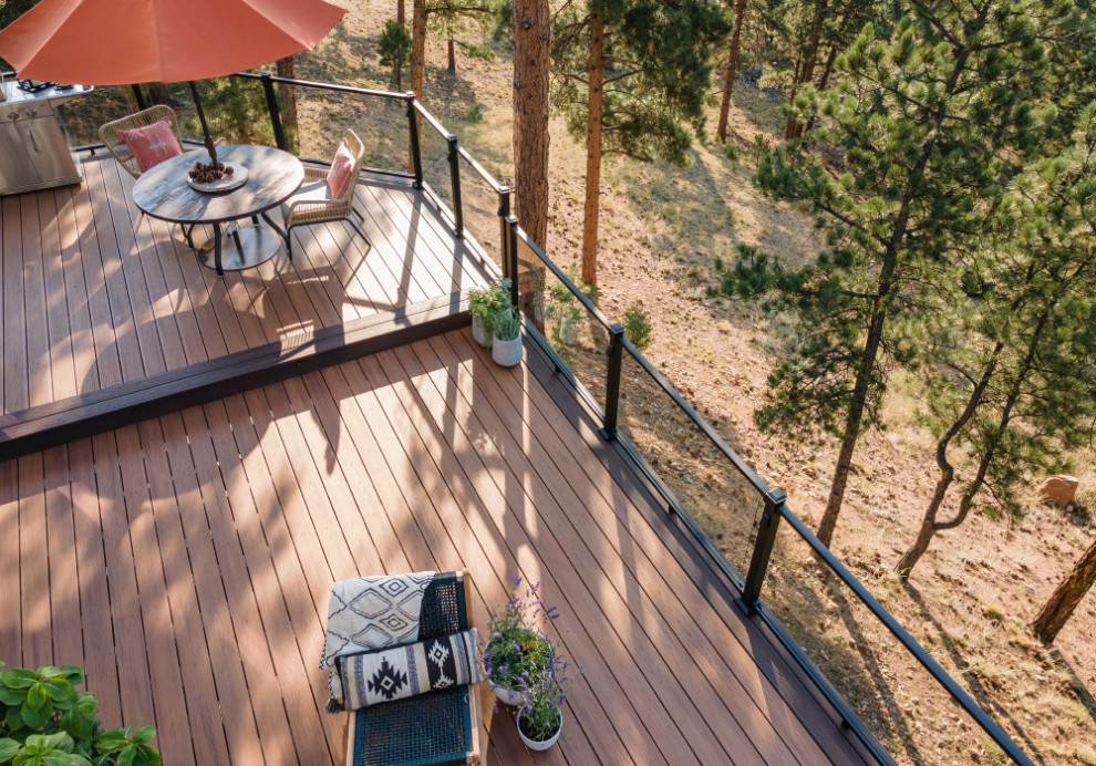 Diseño de terraza de estilo americano sin cubierta en patio trasero con barandilla de vidrio