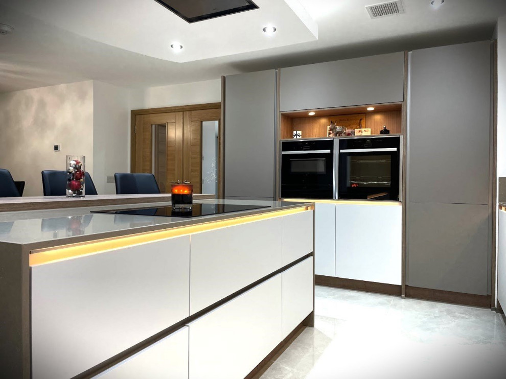 Inspiration for a medium sized modern l-shaped kitchen/diner in Other with a submerged sink, flat-panel cabinets, grey cabinets, quartz worktops, brown splashback, black appliances, an island, white floors and beige worktops.