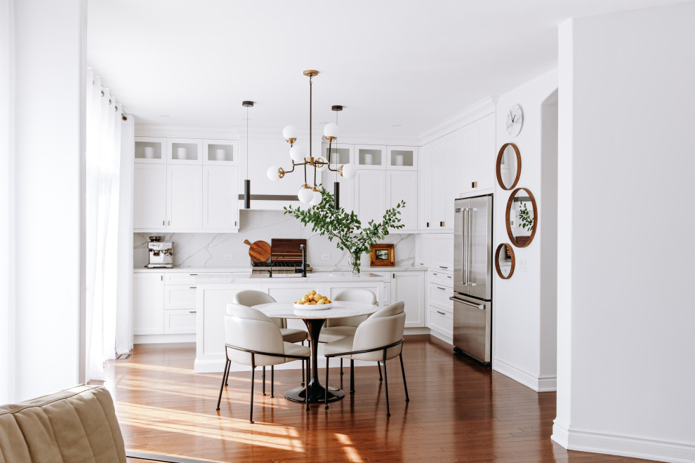 Mid-sized transitional l-shaped dark wood floor and brown floor eat-in kitchen photo in Toronto with an undermount sink, shaker cabinets, white cabinets, quartz countertops, white backsplash, quartz backsplash, black appliances, an island and white countertops