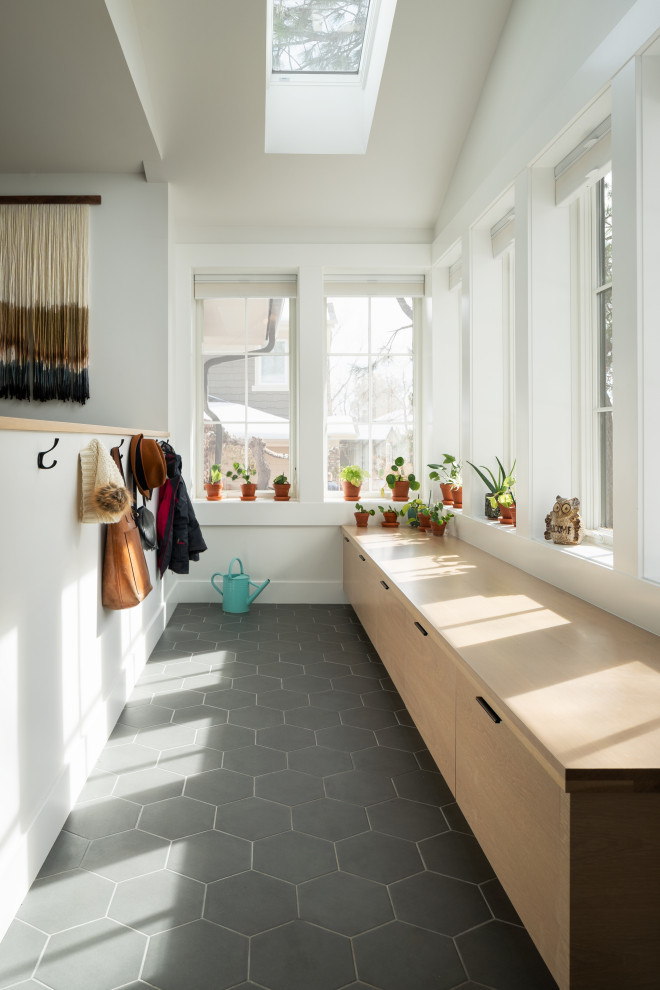 Photo of a mid-sized contemporary mudroom in Denver with white walls, porcelain floors and black floor.
