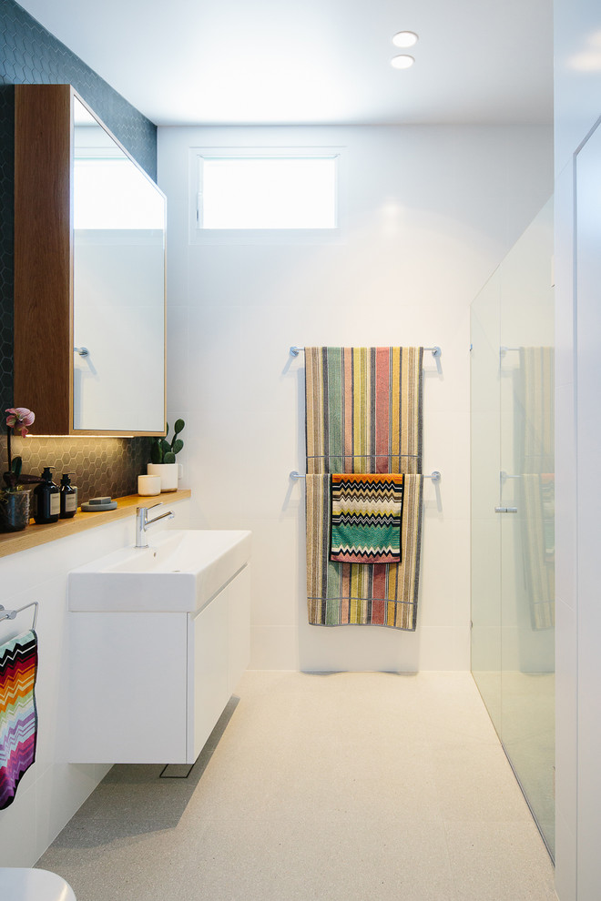 Contemporary bathroom in Other with flat-panel cabinets, white cabinets, a curbless shower, white tile, white walls, a console sink, white floor and a hinged shower door.