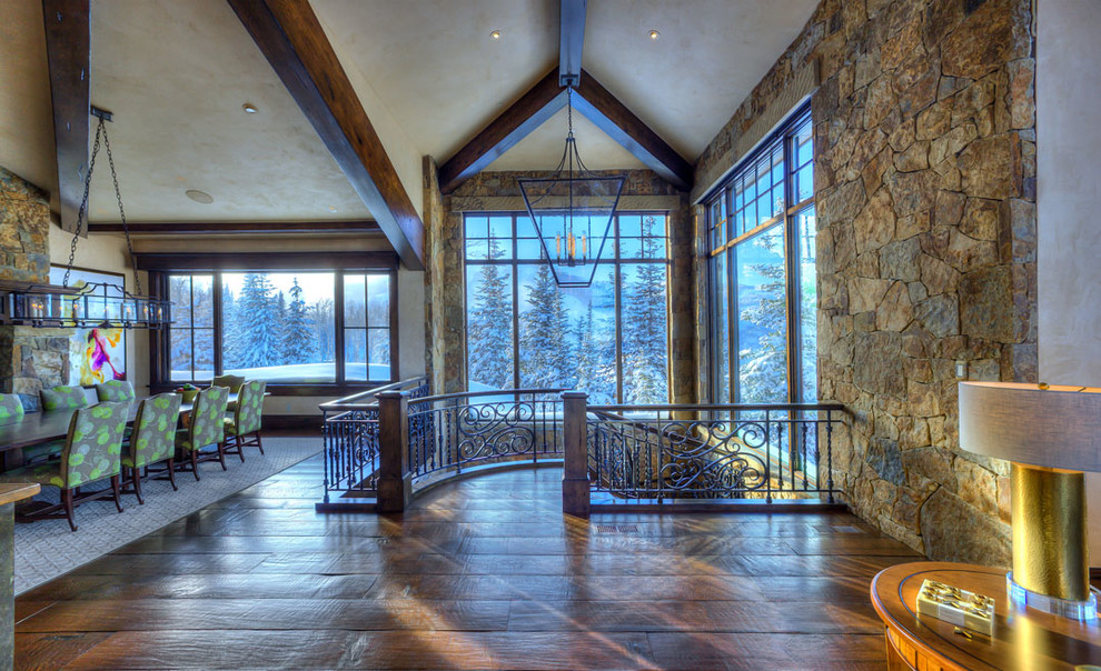 This is an example of an expansive country foyer in Salt Lake City with beige walls, terra-cotta floors, a single front door, a medium wood front door, beige floor and exposed beam.