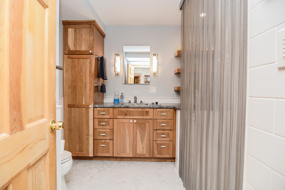Inspiration for a mid-sized transitional master bathroom in Boston with shaker cabinets, medium wood cabinets, an alcove tub, a shower/bathtub combo, a two-piece toilet, white tile, subway tile, blue walls, marble floors, an undermount sink, quartzite benchtops, grey floor, a shower curtain and grey benchtops.