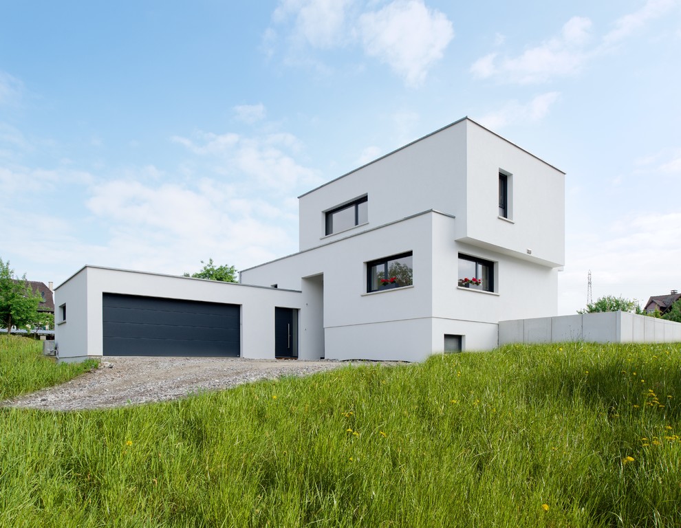 This is an example of a contemporary two-storey white house exterior in Strasbourg with a flat roof.