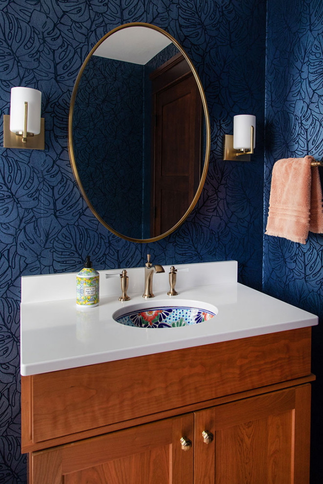 This is an example of a small arts and crafts bathroom in Other with shaker cabinets, medium wood cabinets, a two-piece toilet, blue walls, ceramic floors, an undermount sink, granite benchtops, brown floor, white benchtops, a single vanity, a built-in vanity and wallpaper.
