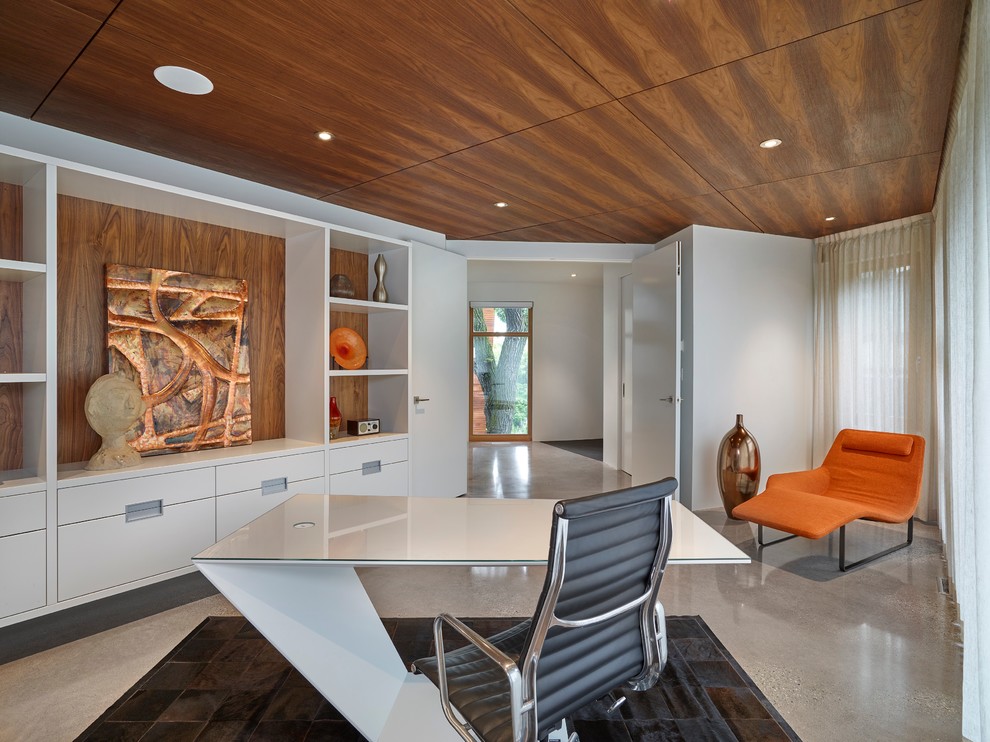 Inspiration for a large contemporary freestanding desk concrete floor study room remodel in Calgary with white walls and no fireplace