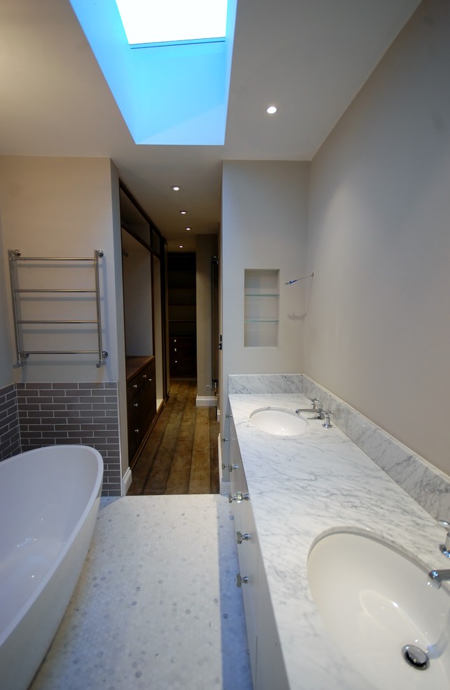 Mid-sized contemporary master bathroom in London with an undermount sink, flat-panel cabinets, white cabinets, marble benchtops, a drop-in tub, an open shower, a wall-mount toilet, gray tile, ceramic tile, grey walls and mosaic tile floors.