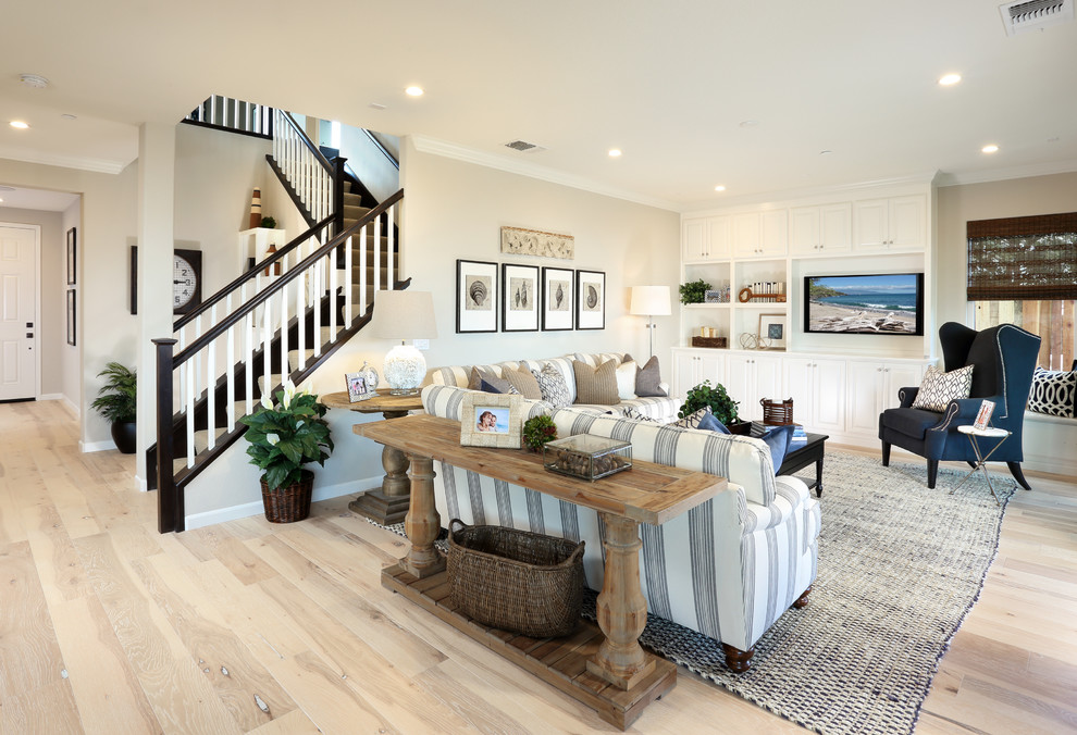 Beach style open concept living room in San Francisco with beige walls, light hardwood floors and a built-in media wall.