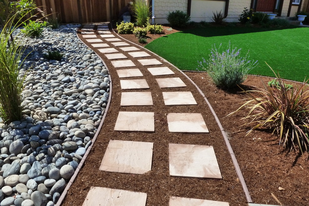 Photo of a mid-sized transitional front yard partial sun garden for spring in San Francisco with natural stone pavers and a garden path.