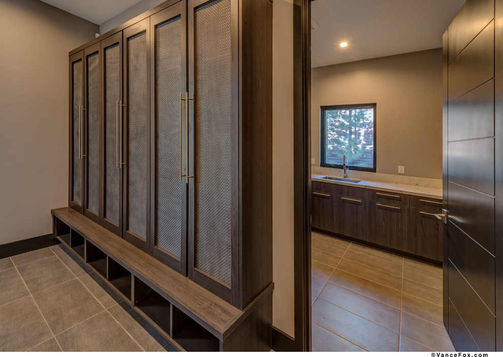 Photo of a mid-sized contemporary l-shaped dedicated laundry room in Other with an undermount sink, flat-panel cabinets, brown cabinets, quartzite benchtops, grey walls, ceramic floors, grey floor and white benchtop.
