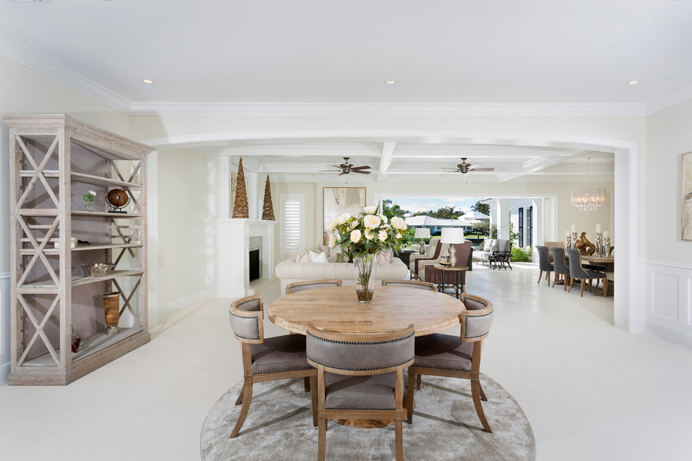 This is an example of a tropical open plan dining in Other with white walls, ceramic floors, white floor, a standard fireplace and a plaster fireplace surround.