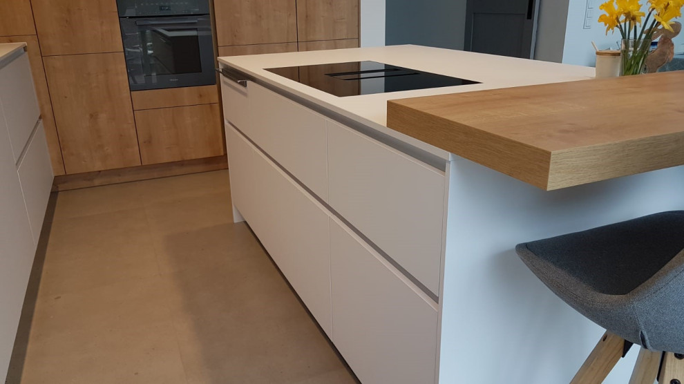 This is an example of a large contemporary kitchen in Other with concrete floors, with island and white benchtop.