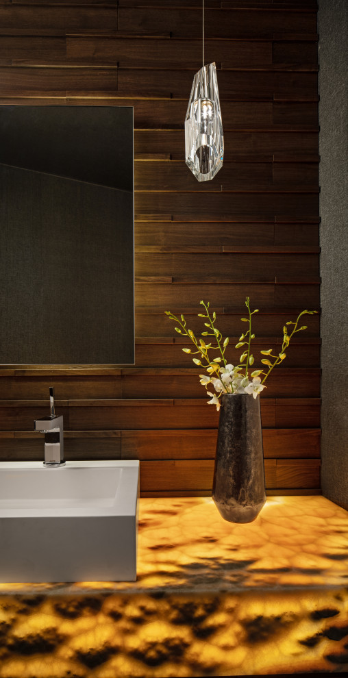 Идея дизайна: туалет в стиле модернизм с унитазом-моноблоком, коричневой плиткой, плиткой под дерево, коричневыми стенами, паркетным полом среднего тона, настольной раковиной, столешницей из оникса, разноцветной столешницей, подвесной тумбой, потолком с обоями и деревянными стенами
