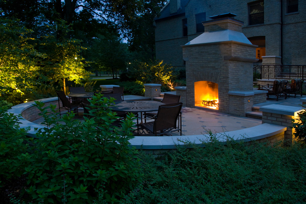Photo of a large traditional backyard shaded garden for summer in Chicago with a fire feature and natural stone pavers.