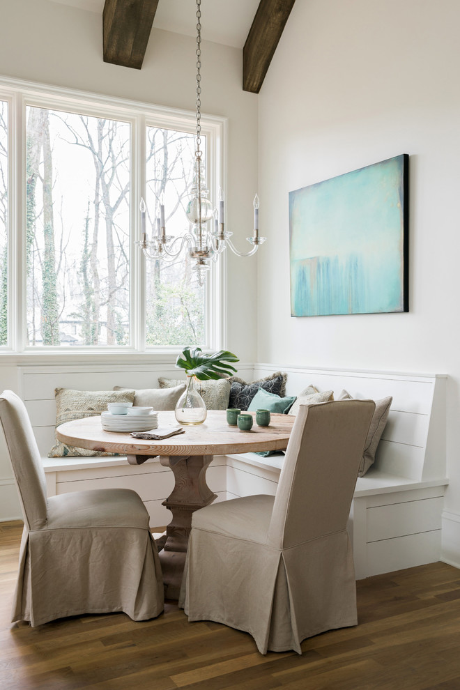This is an example of a beach style dining room in Atlanta with white walls, medium hardwood floors and no fireplace.