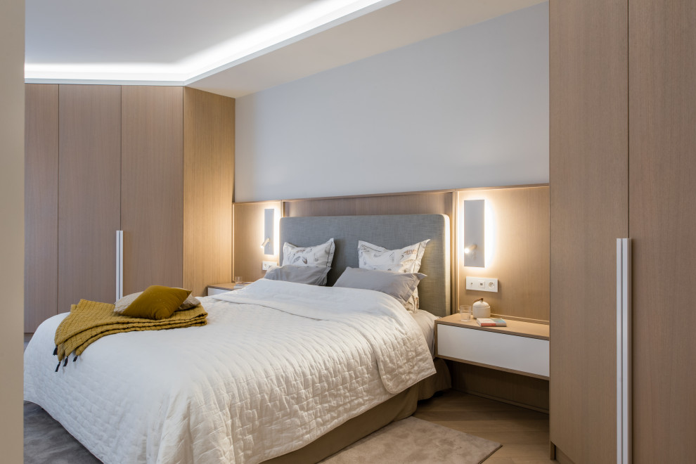 Foto de dormitorio actual con paredes blancas, suelo de madera clara, suelo beige, bandeja y madera