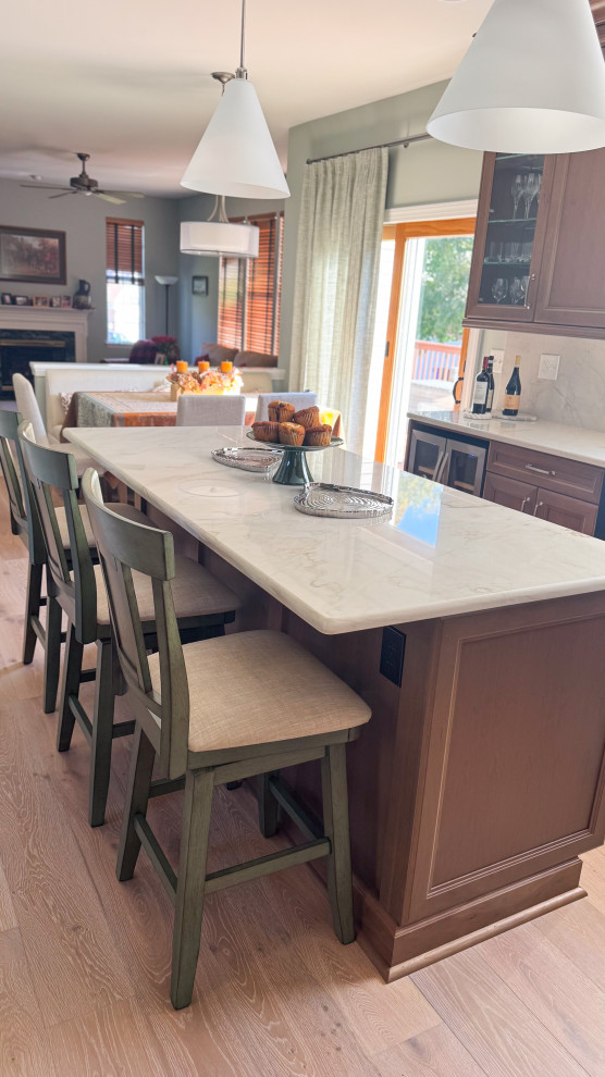 Inspiration for a mid-sized coastal light wood floor eat-in kitchen remodel in Baltimore with recessed-panel cabinets, medium tone wood cabinets, quartzite countertops, stainless steel appliances, an island and white countertops