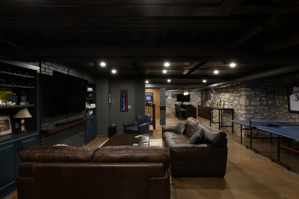This is an example of a large rustic fully buried basement in Kansas City with a home bar, grey walls, concrete flooring, brown floors and brick walls.