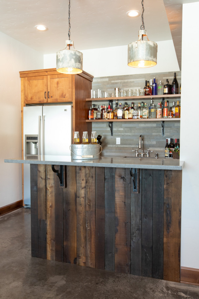 Inspiration for a mid-sized country galley wet bar in Portland with an undermount sink, shaker cabinets, light wood cabinets, quartz benchtops, grey splashback, slate splashback, concrete floors, grey floor and grey benchtop.
