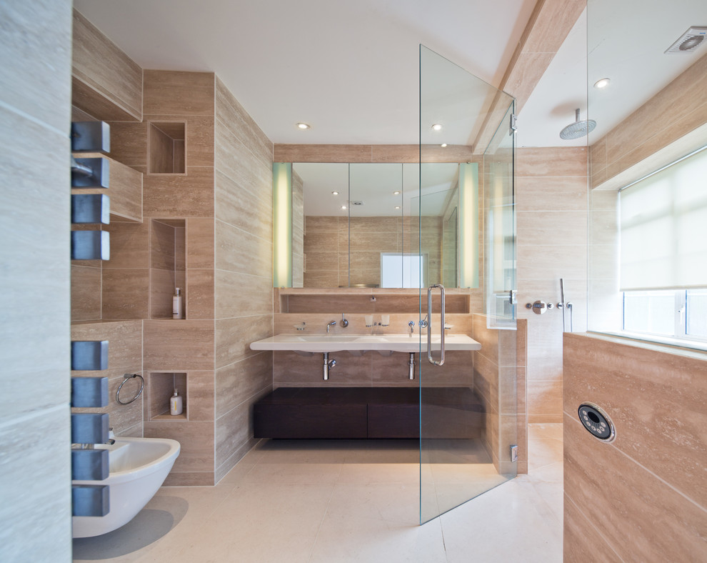 Photo of a contemporary bathroom in London with a wall-mount sink, flat-panel cabinets, dark wood cabinets, an alcove shower, a bidet, beige tile and ceramic floors.