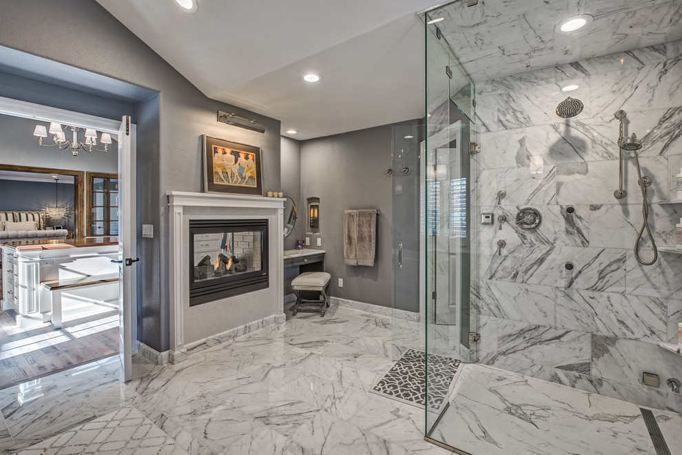 Photo of a large transitional master bathroom in Denver with raised-panel cabinets, grey cabinets, a freestanding tub, a curbless shower, a one-piece toilet, white tile, stone tile, grey walls, marble floors, an undermount sink and marble benchtops.