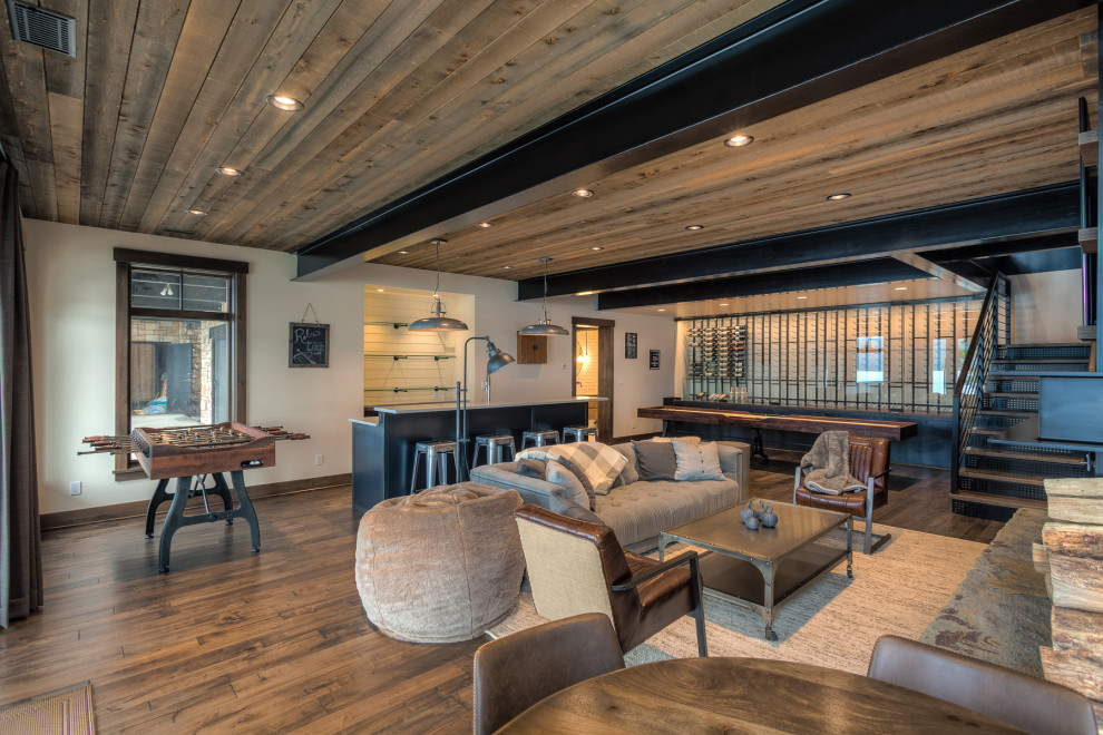 Cette image montre un sous-sol design donnant sur l'extérieur avec un bar de salon et un plafond en bois.