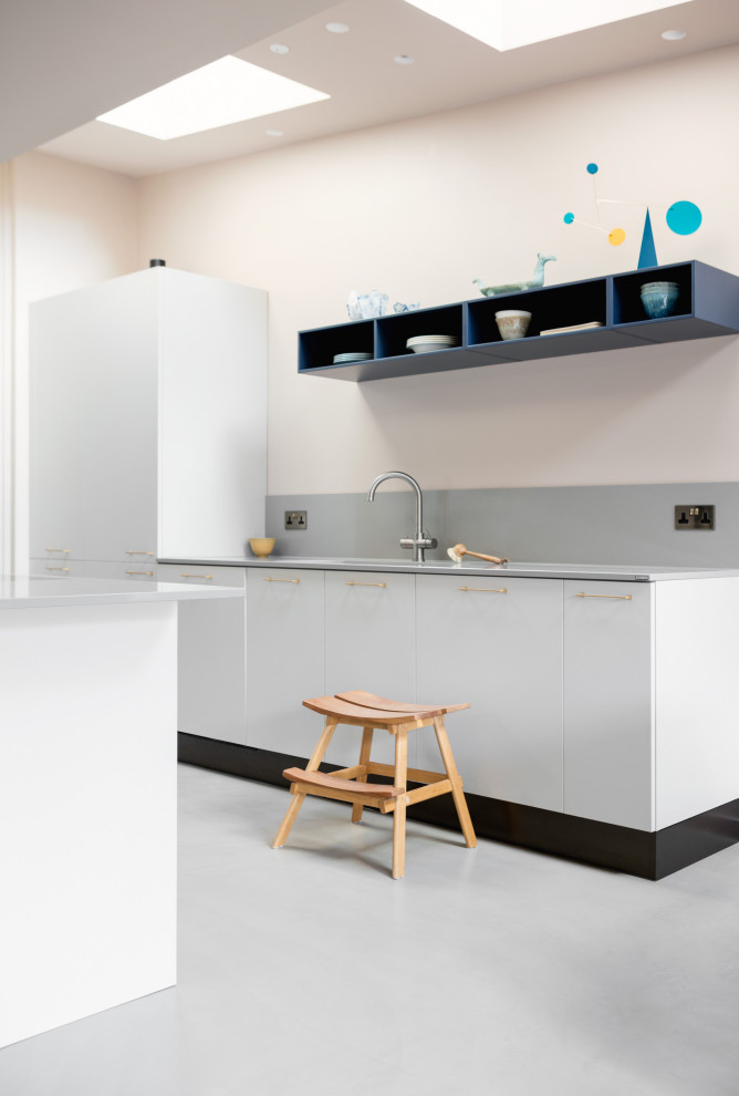 Foto di una cucina eclettica di medie dimensioni con ante lisce, ante grigie, top in quarzite, elettrodomestici neri e top grigio