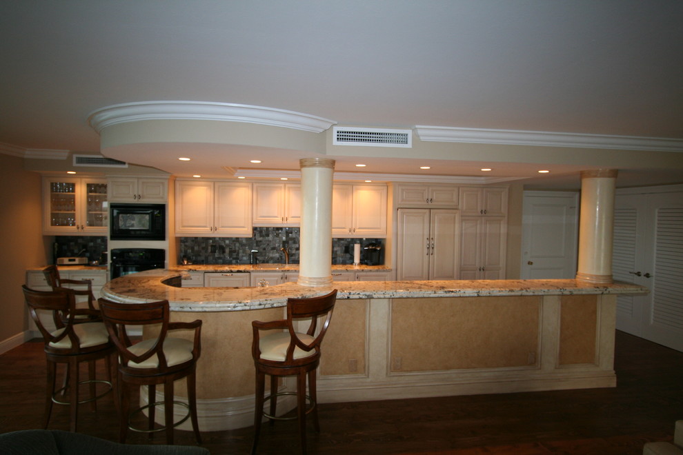 Eat-in kitchen - eat-in kitchen idea in Miami with an undermount sink, raised-panel cabinets, beige cabinets, quartzite countertops, gray backsplash, glass tile backsplash, stainless steel appliances and an island