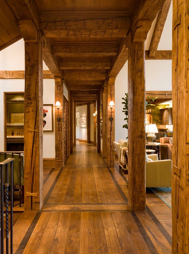 Photo of a large arts and crafts hallway in Denver with white walls, medium hardwood floors and brown floor.