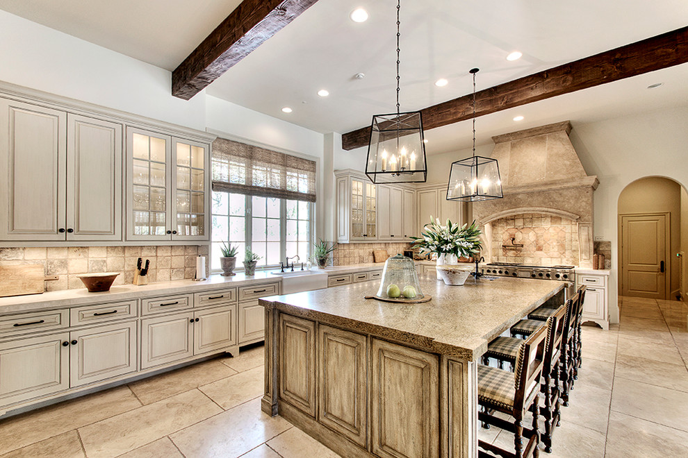 Photo of a traditional kitchen in Houston with a farmhouse sink, raised-panel cabinets, beige cabinets, beige splashback, stone tile splashback and stainless steel appliances.