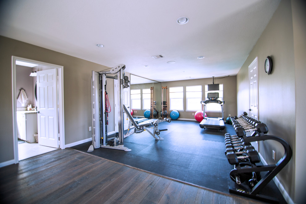 Inspiration for a large traditional home weight room in Houston with brown walls and dark hardwood floors.